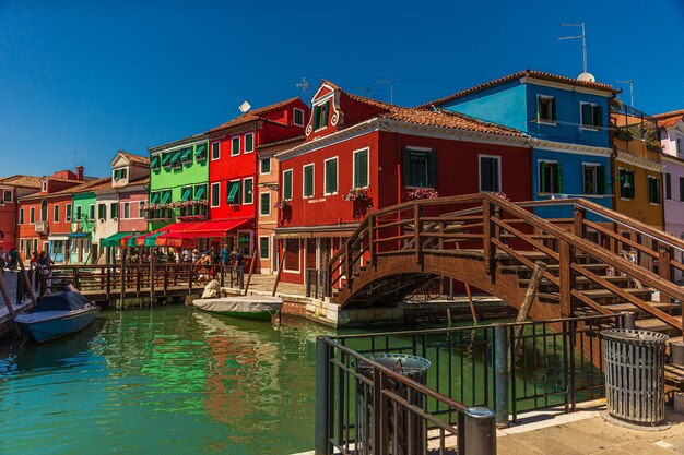 Foto barche ormeggiate nel canale da edifici contro il cielo blu
