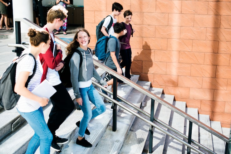 Foto gruppo di amici della scuola che cammina giù per la scala