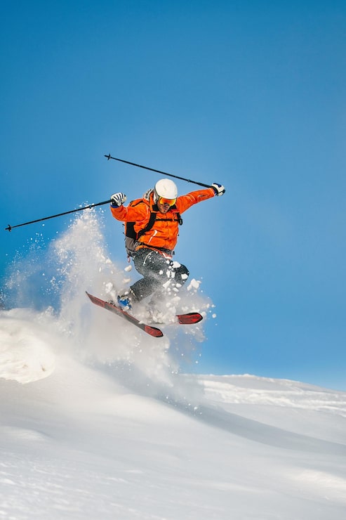 Foto lo sciatore freerider salta nella neve profonda