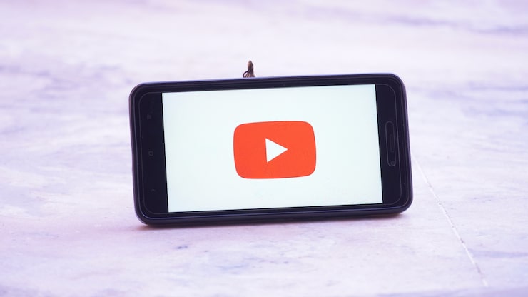 Photo logo layar splash youtube di ponsel dan ponsel di tangan