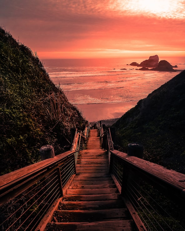 Foto grátis ponte de madeira para a praia durante o pôr do sol