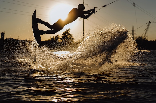 Foto grátis wakeboard. wakeboard saltando ao pôr do sol