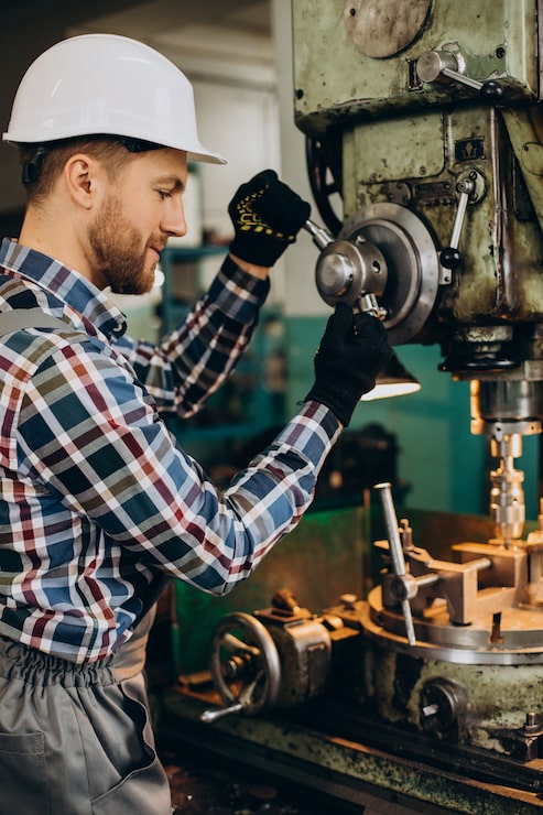 Kostenlose Foto arbeiter mit hut bei der arbeit mit metallkonstruktionen in einer fabrik