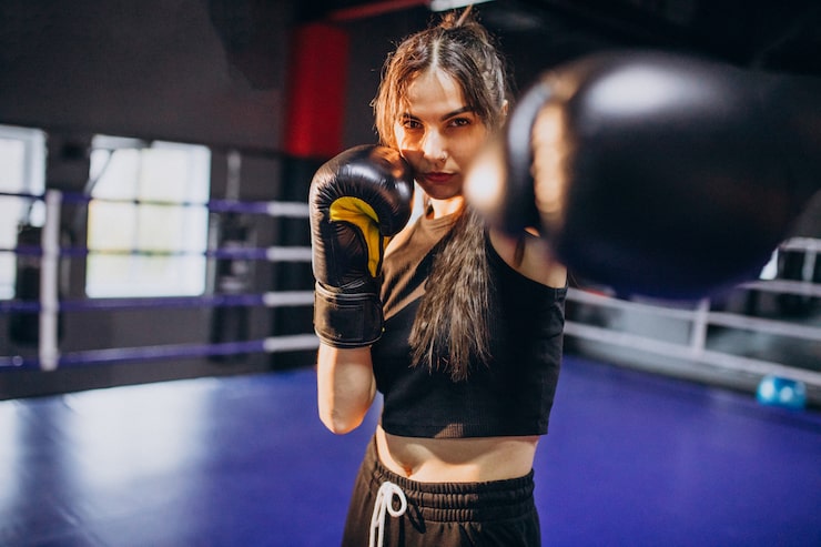 Kostenlose Foto junge boxerin trainiert im fitnessstudio