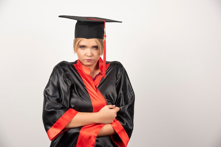 Kostenlose Foto junger student im aufbaustudium im kleid, das auf weiß steht.