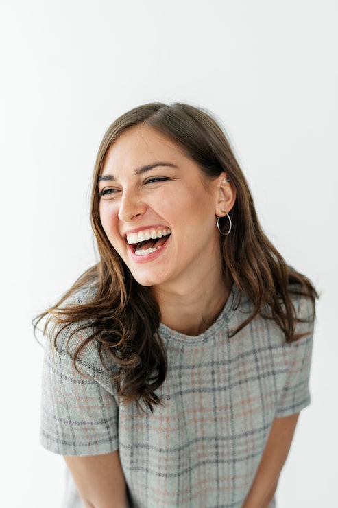 Foto mujer sonriente con un vestido a cuadros gris