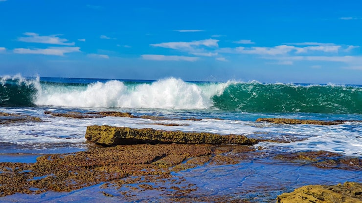 Foto ola de barril en una playa rocosa