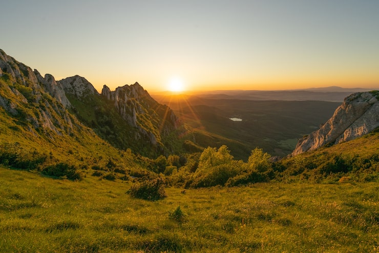 Gratis Foto fascinerende bilde av en grønn steinete ås under den vakre solnedgangstimen