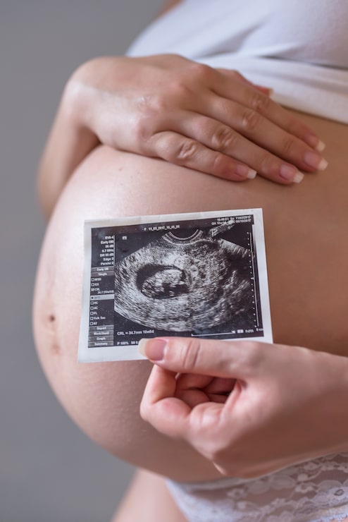 Gratis Foto gravid kvinne som holder bilde av sin fremtidige baby