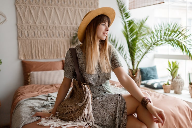 Gratis Foto kvinne som sitter på sengen i sin boho-leilighet