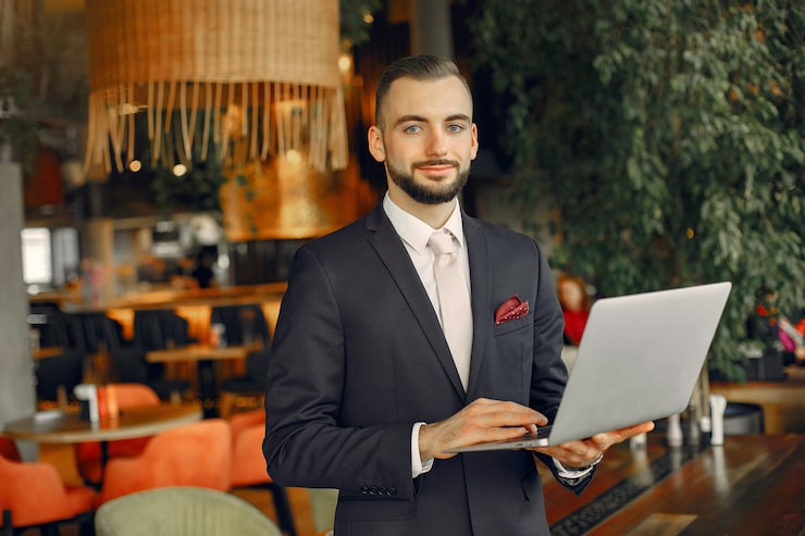 Gratis Foto mann som jobber med en bærbar datamaskin ved bordet