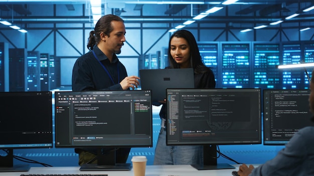 Gratis Foto programmerer og veileder i serverrom som brainstormer