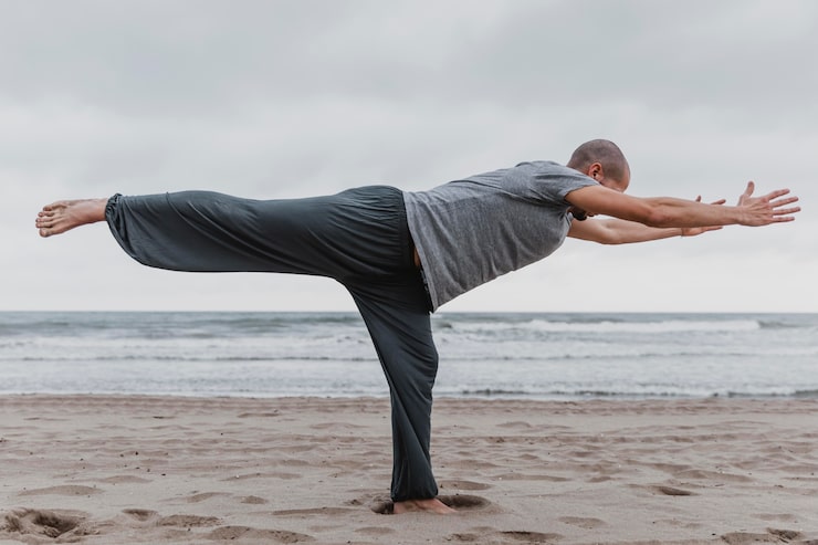 Gratis Foto sidevisning av mann som praktiserer yoga på stranden