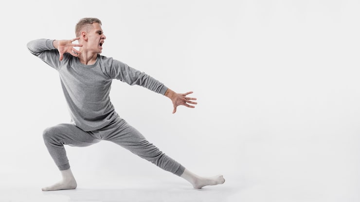 Gratis Foto sidevisning av mannlig danser i treningsdress og sokker som poserer