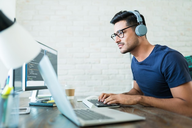 Gratis Foto flot ung mandlig softwareudvikler programmerer koder mens han arbejder hjemmefra