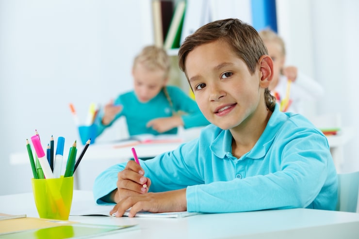 Gratis Foto folkeskoleelev holder en blyant