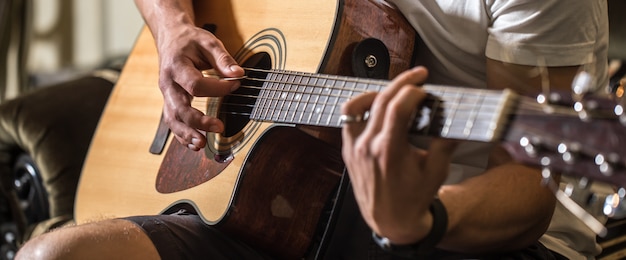 Gratis Bild kille som spelar akustisk gitarr