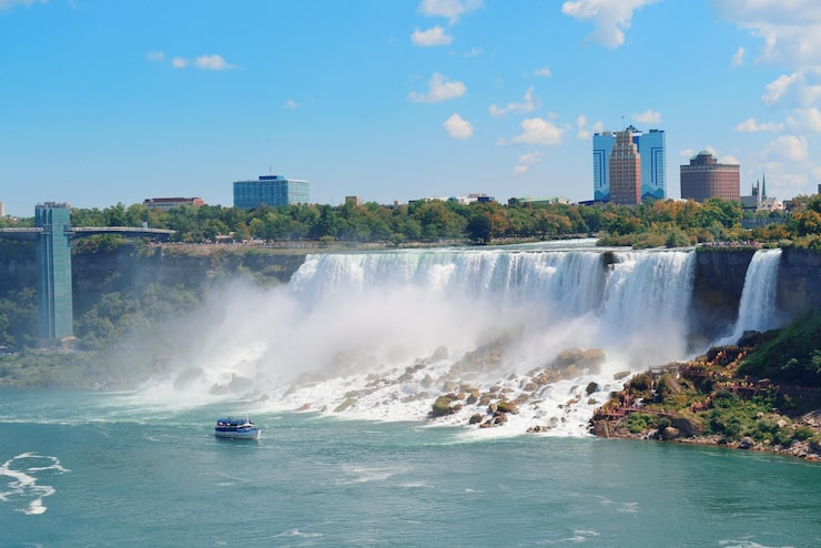 Gratis Bild niagarafallens närbild under dagen över floden med stenar och båt