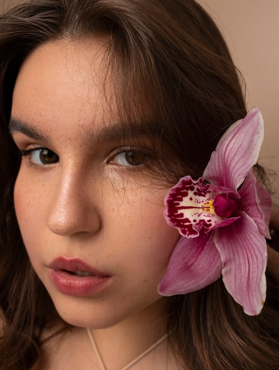 Gratis Bild sida ung kvinna som poserar med blomma