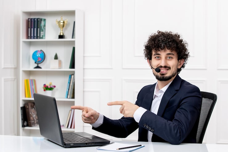 Miễn phí Photo dịch vụ khách hàng người đàn ông xoăn điển trai mặc vest công sở với máy tính và tai nghe đang mỉm cười