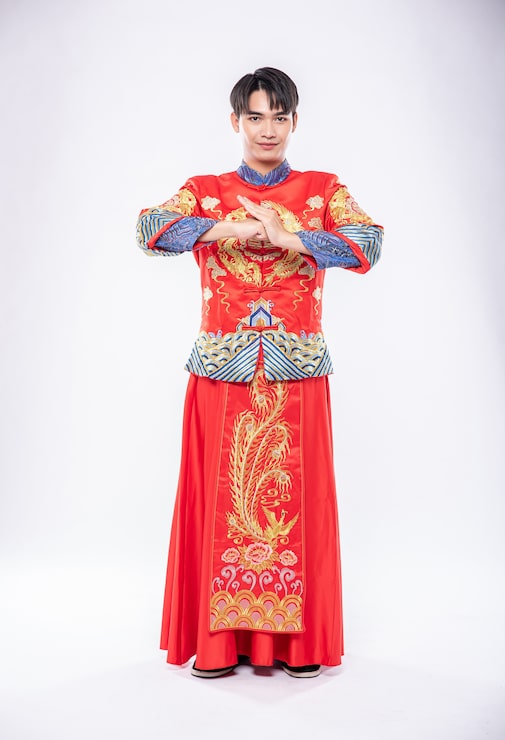 Miễn phí Photo người đàn ông mặc sườn xám mỉm cười và đứng chào đón khách hàng đến mua sắm trong năm mới