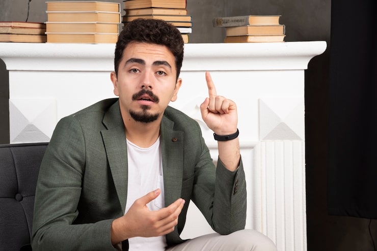 Miễn phí Photo người đàn ông trẻ tuổi trầm tư đang chỉ ngón tay lên.