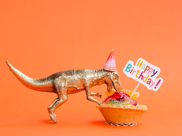 Ilmainen Kuva lelu dinosaurus syö syntymäpäivämakeisia