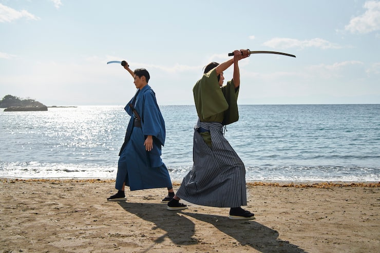 Ilmainen Kuva samurai taistelee miekoilla rannalla