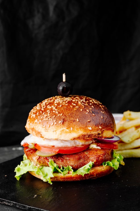 Photo gratuit burger avec viande, tomates et laitue en chignon.