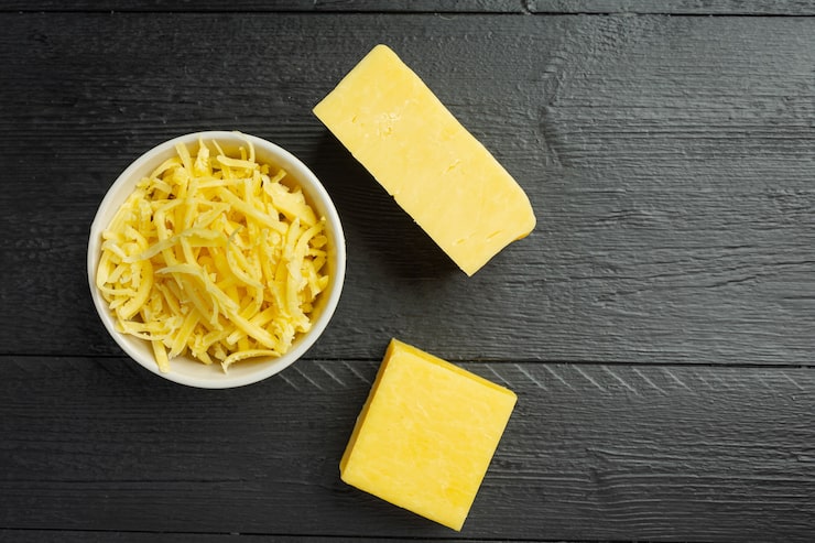 Photo gratuit fromage cheddar sur une surface en bois sombre