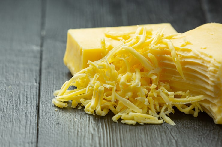 Photo gratuit fromage cheddar sur une surface en bois sombre