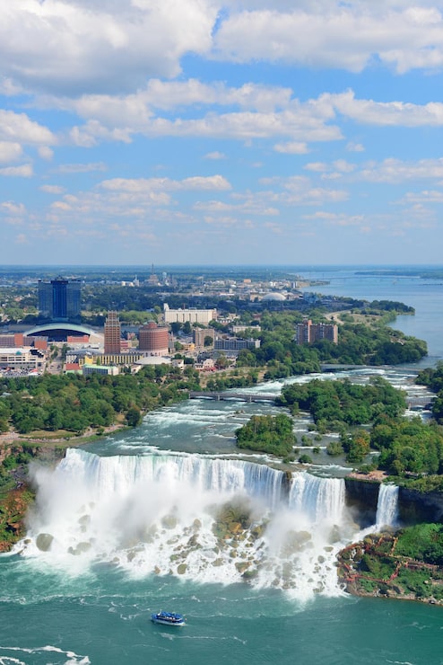 Photo gratuit gros plan des chutes du niagara dans la journée sur la rivière avec des bâtiments