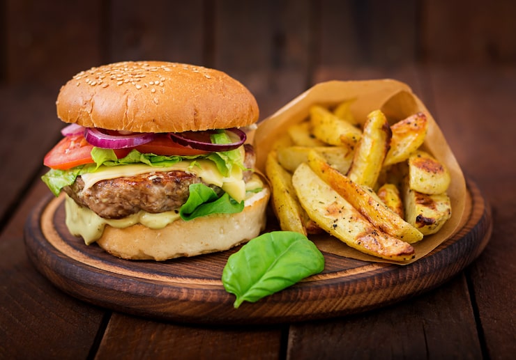 Photo gratuit gros sandwich - hamburger avec burger de boeuf juteux, fromage, tomate et oignon rouge sur table en bois