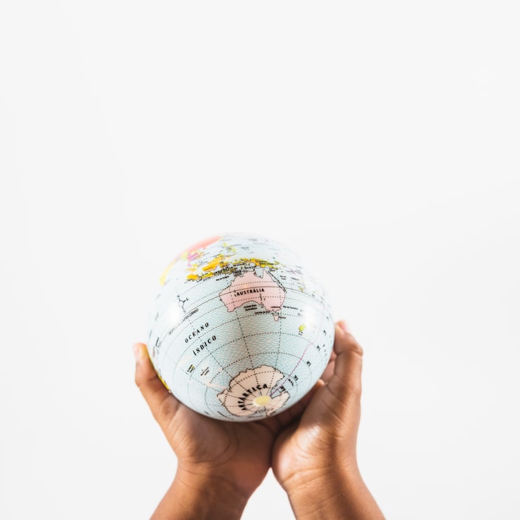 Photo gratuit mains avec globe en studio