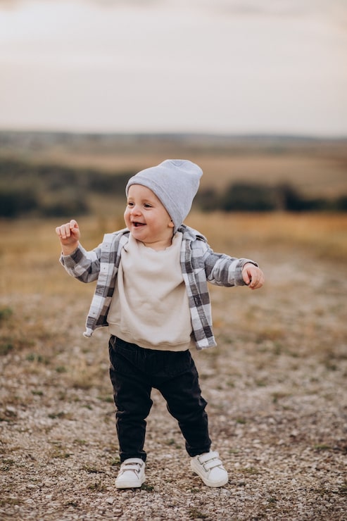 Photo gratuit un mignon petit garçon qui s'amuse dans le champ.