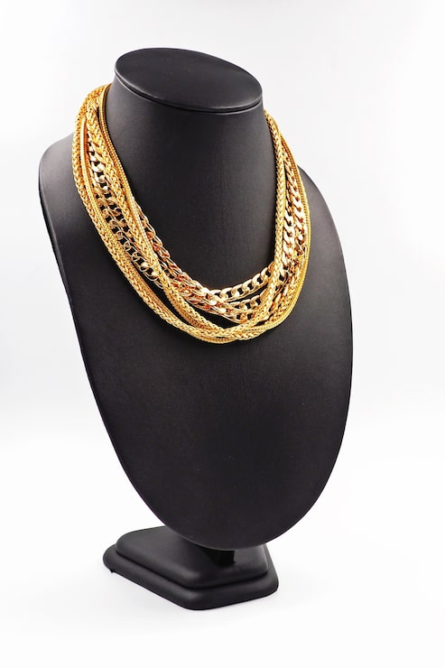 Photo collier en or sur le présentoir de collier.
