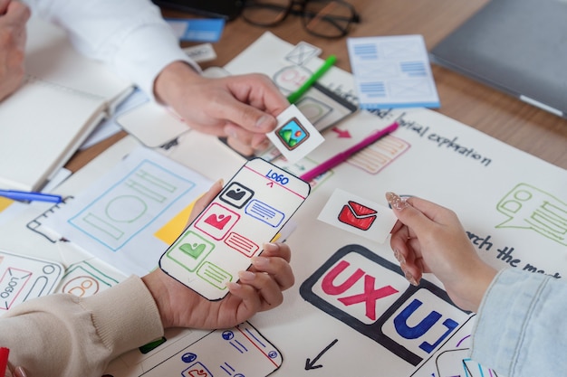 Photo designers ux ui prototypant une interface d'application mobile avec des wireframes papier