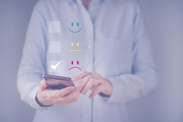 Photo une femme d'affaires donne un emoticon de visage triste sur l'écran tactile virtuel de son smartphone concept de service à la clientèle évaluation questionnaire de satisfaction rétroaction utilisateur donne une note à l'expérience de service
