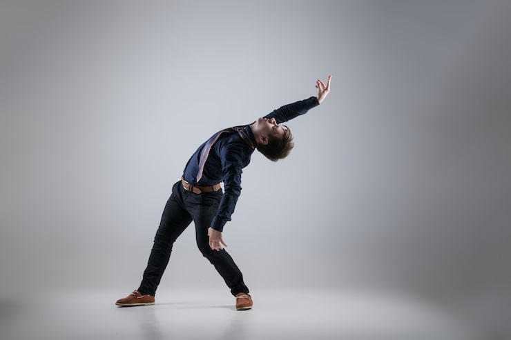 Foto ung attraktiv mann danser på hvit bakgrunn