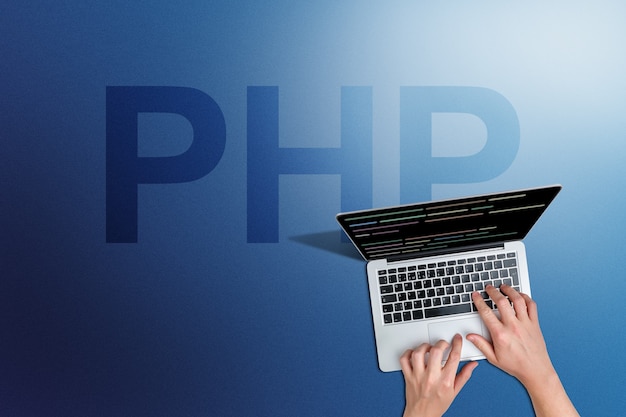 Foto programmeertaal php-code met persoon en laptop.