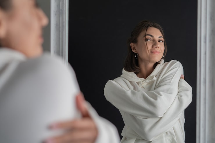 Gratis Foto jonge vrouw in witte capuchon poseert in de spiegel